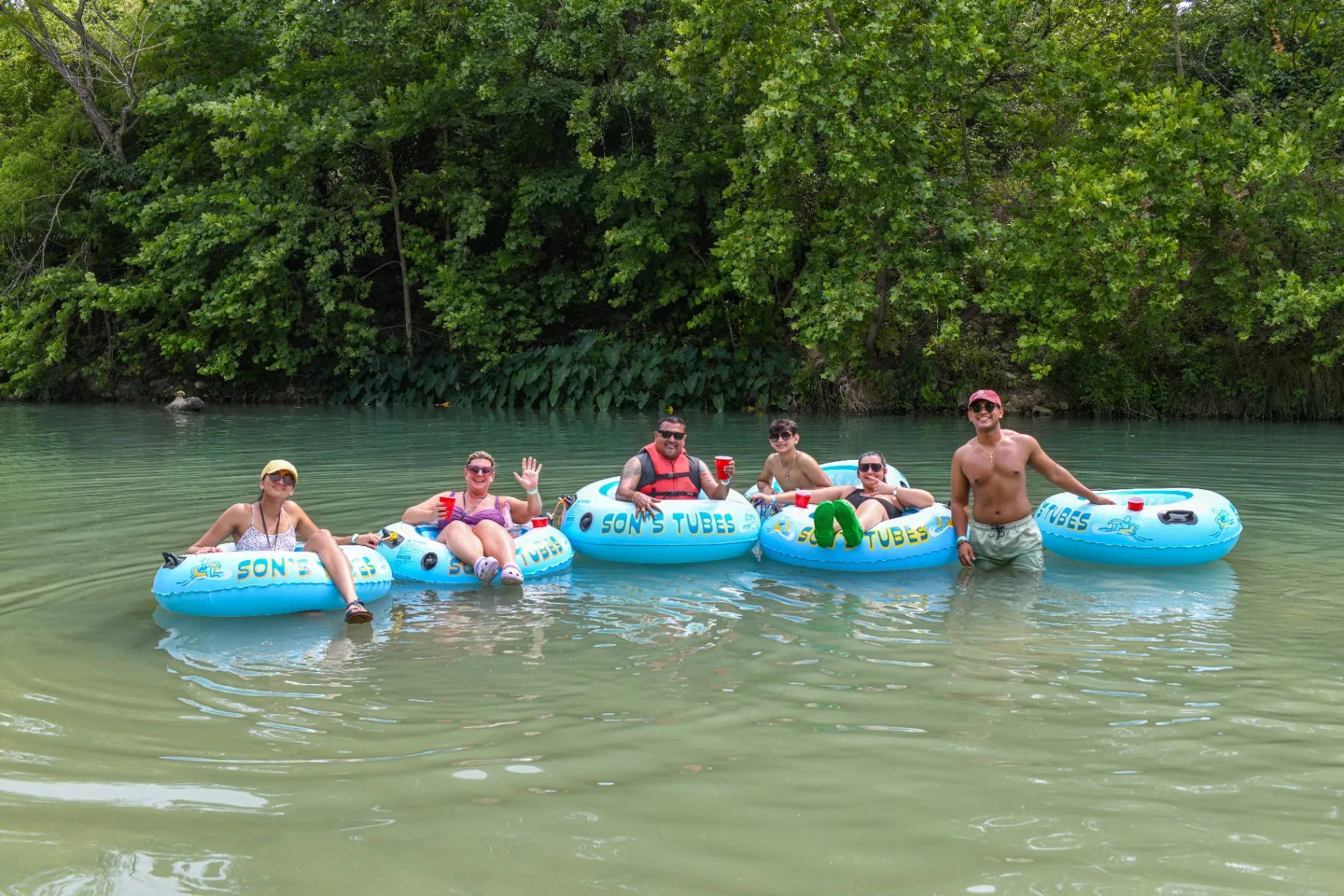 Friends enjoying tubing on the San Marcos River at Son's Blue River Camp